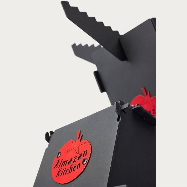 Angled close up of the Foldable Rocket Stove with the Almazan Kitchen logo at the forefront. 