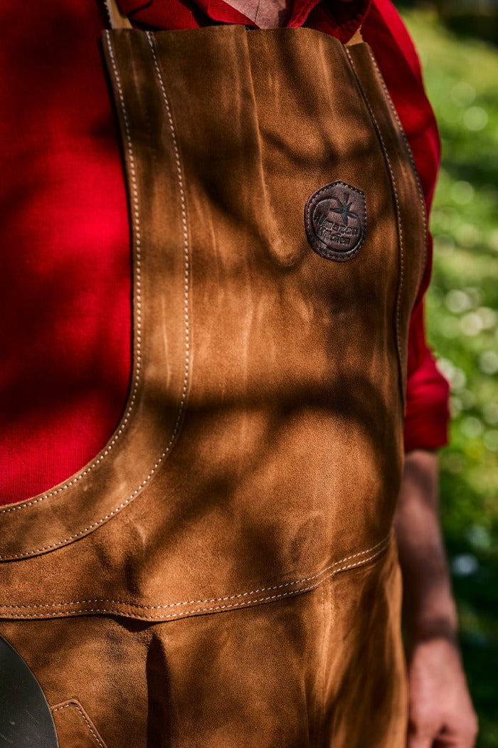 Leather apron with an Almazan Kitchen logo on the chest.
