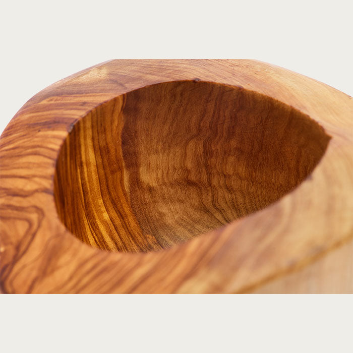 Close up of a olive wood mortar with a beautiful wood grain on a white background.