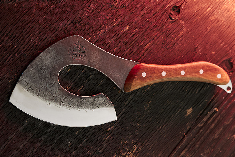 Carboon Steel Cooking Axe from Almazan Kitchen illuminated by a flame.