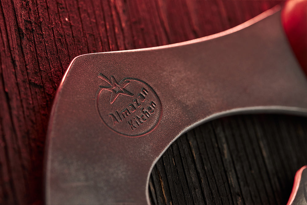 Close up of a Almazan Kitchen logo on the head of a cooking axe.