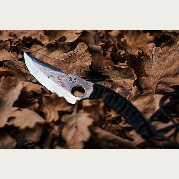 Almazan Kitchen Predator Knife on a bed of fallen leaves. 