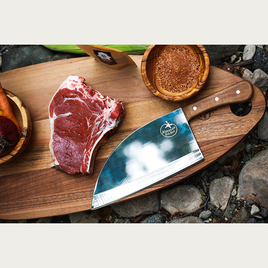 Almazan Kitchen Steak Knife on a cutting board next to a piece of steak and spices