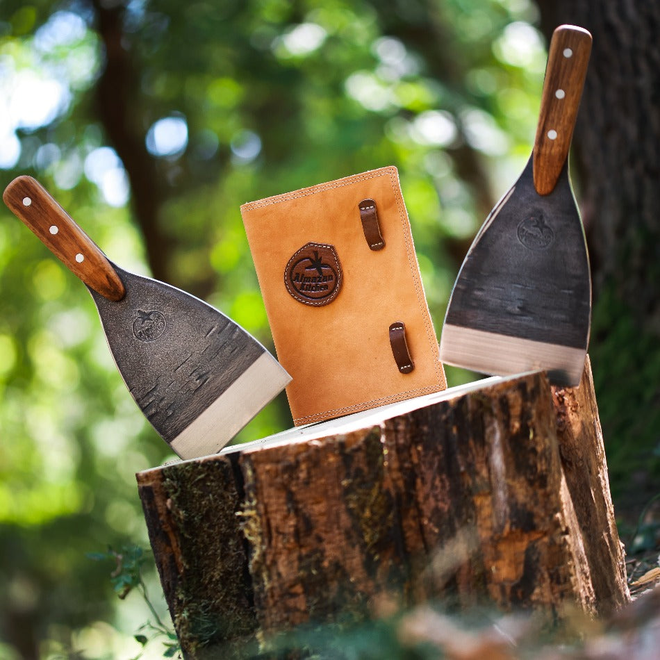 Two Almazan Kitchen Spatulas on a tree trunk, with the sheath behindthem