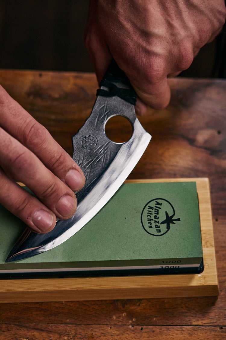 Person sharpening a Predator knife on a Almazan Kitchen sharpening stone.