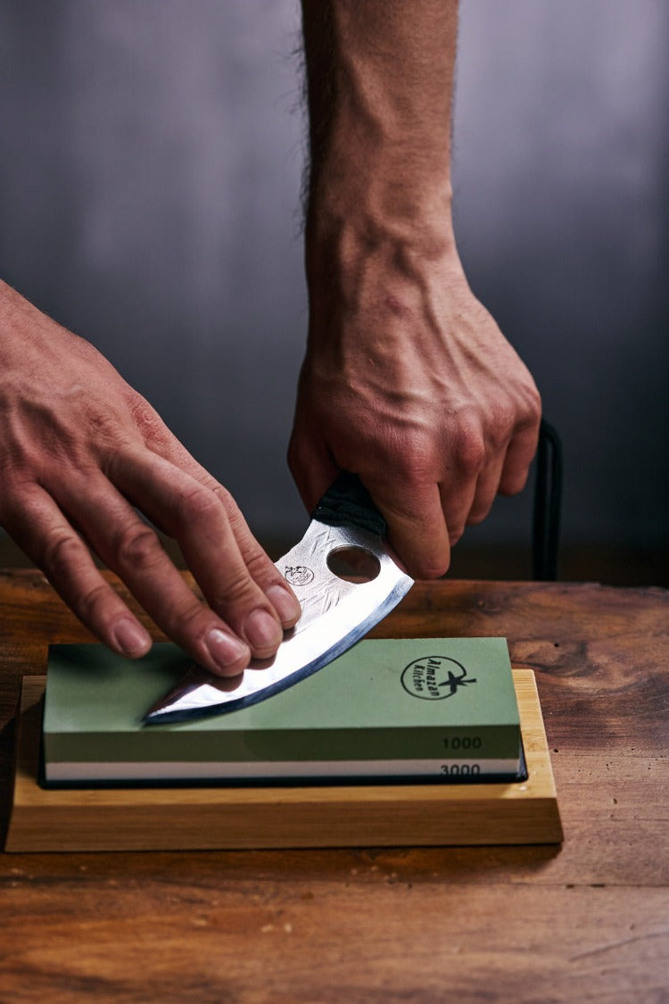 Person sharpening a Predator knife on a Almazan Kitchen sharpening stone.