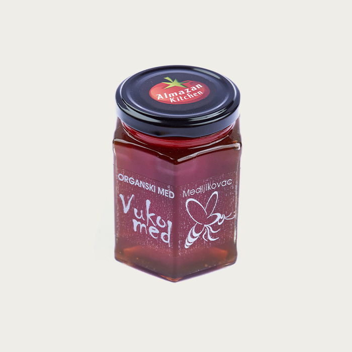 A jar of Almazan Kitchen organic honey on a white background.