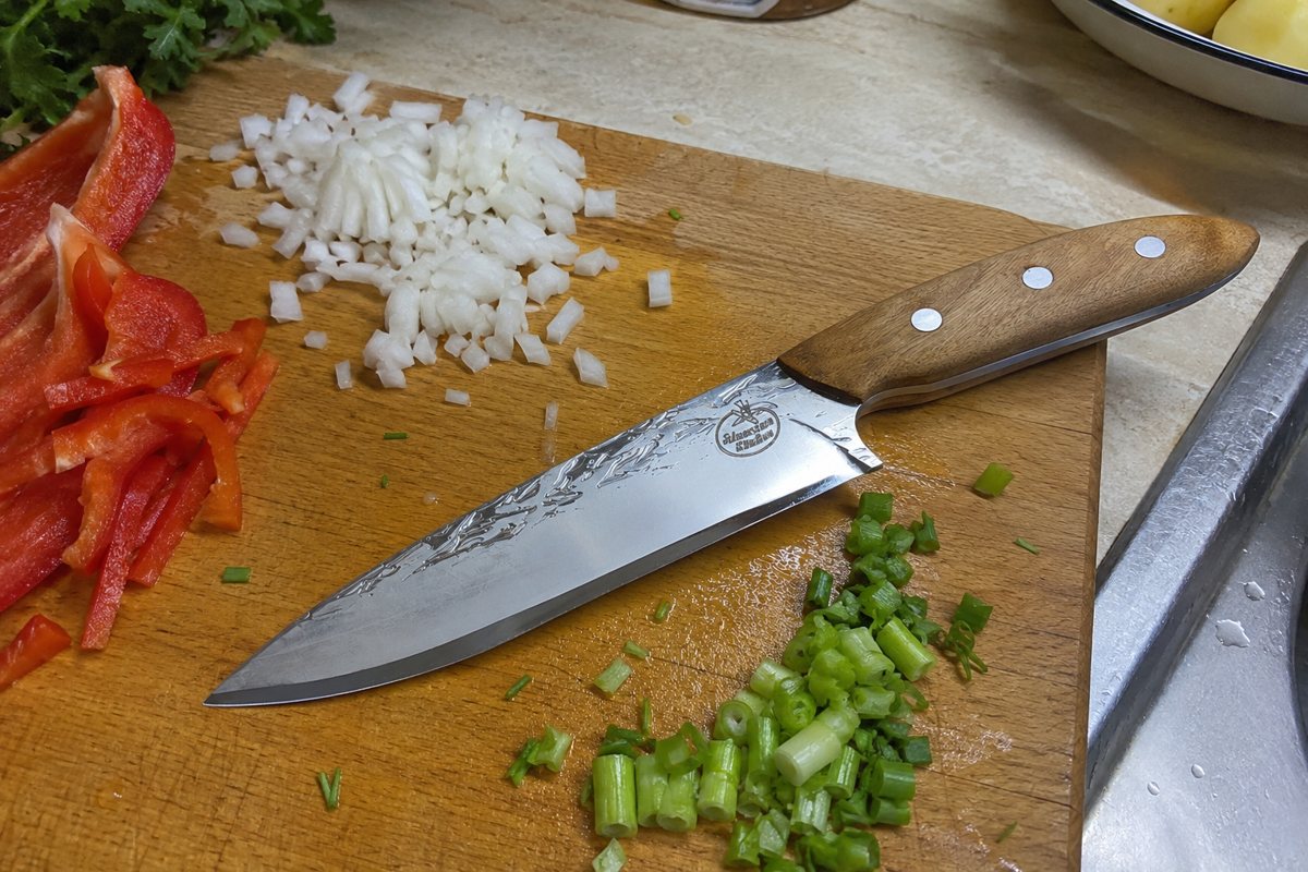 Forged kitchen knife with chopped vegetables